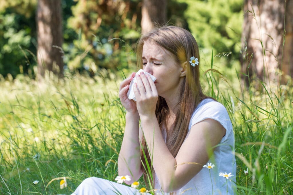 Woman in the meadow sneezes, the concept of an allergy